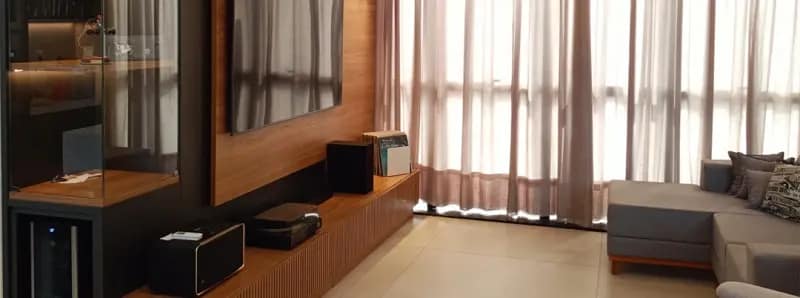 Living com painel de TV em madeira, adega e rack suspenso planejados