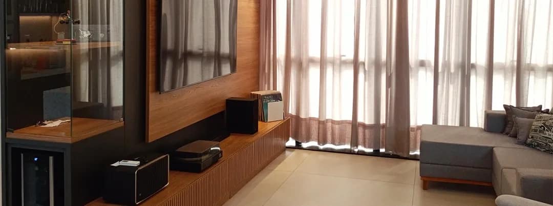 Sala de estar com painel de TV e adega planejados